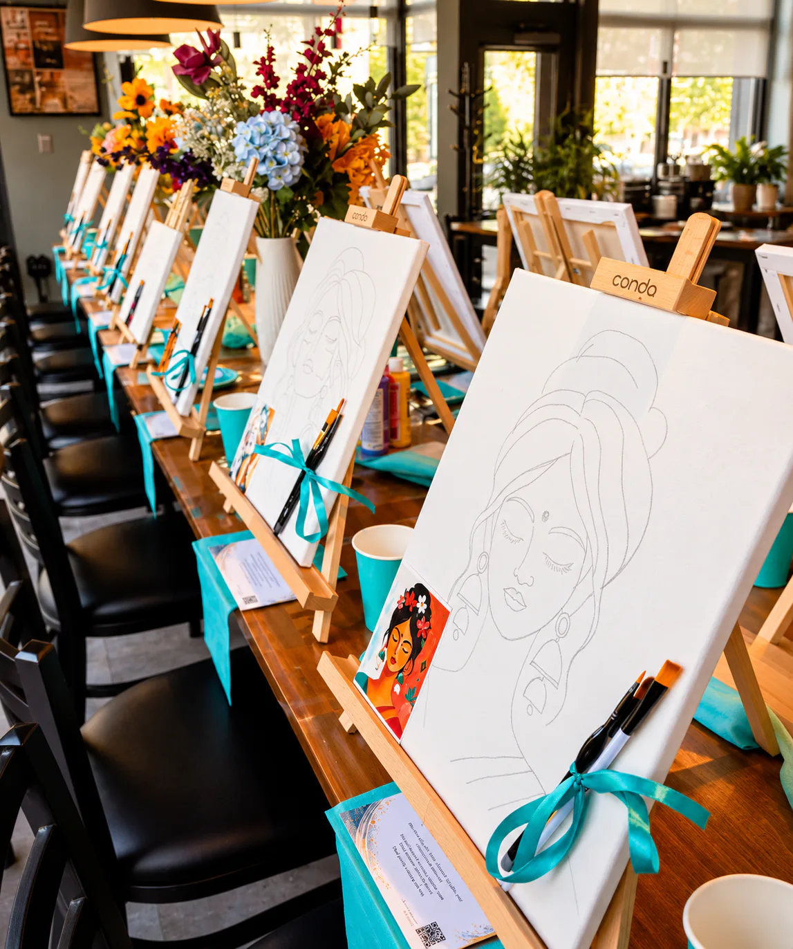 Table préparée pour un événement Arty avec chevalets, toiles et matériel de peinture
